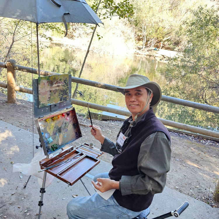 Calvin Liang at his easel painting trees